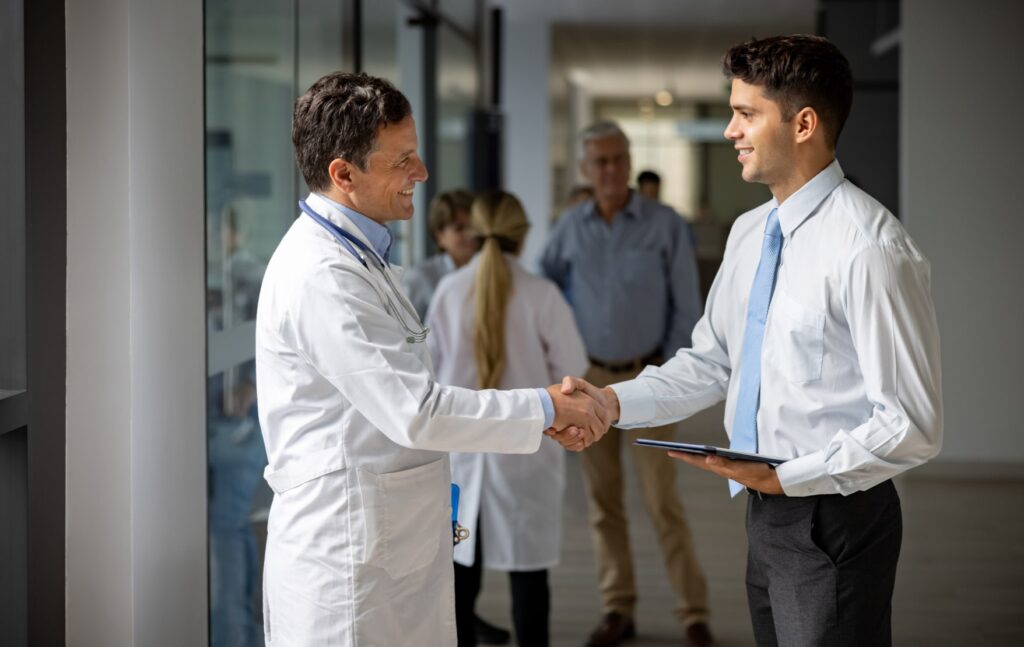 Doctor and businessman trualign partners shaking hands, business handshake in healthcare