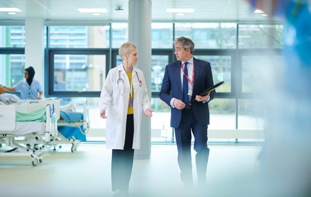 Doctor and businessman partners walking together in healthcare facility, illustrating trualign collaboration