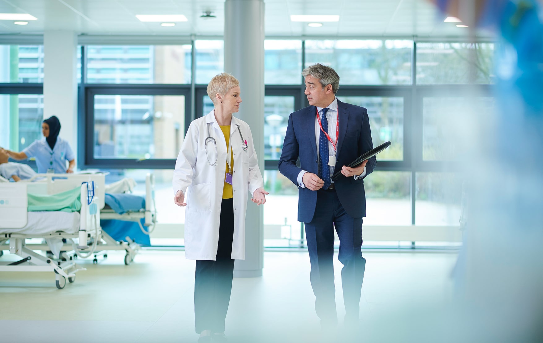 Doctor and businessman partners walking together in healthcare facility, illustrating trualign collaboration